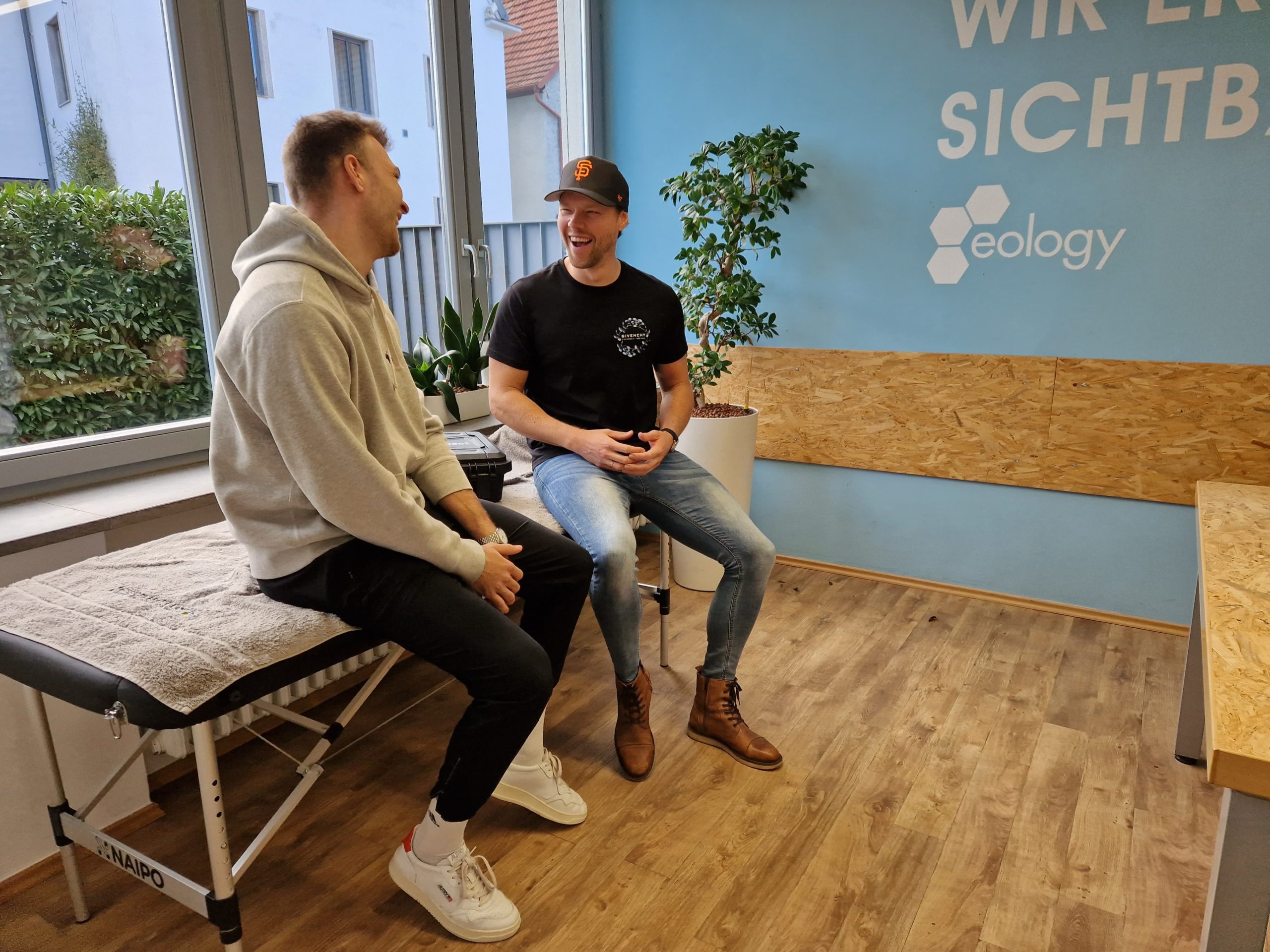 Zu sehen sind Physiotherapeut Max und Gründer von eology Daniel Unger im Besprechungsraum von eology.