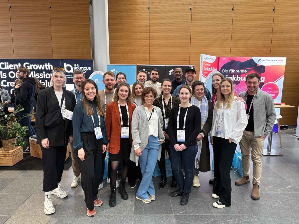 Zu sehen ist das eology-Team vor dem eology Messestand auf der SMX in München 2024.